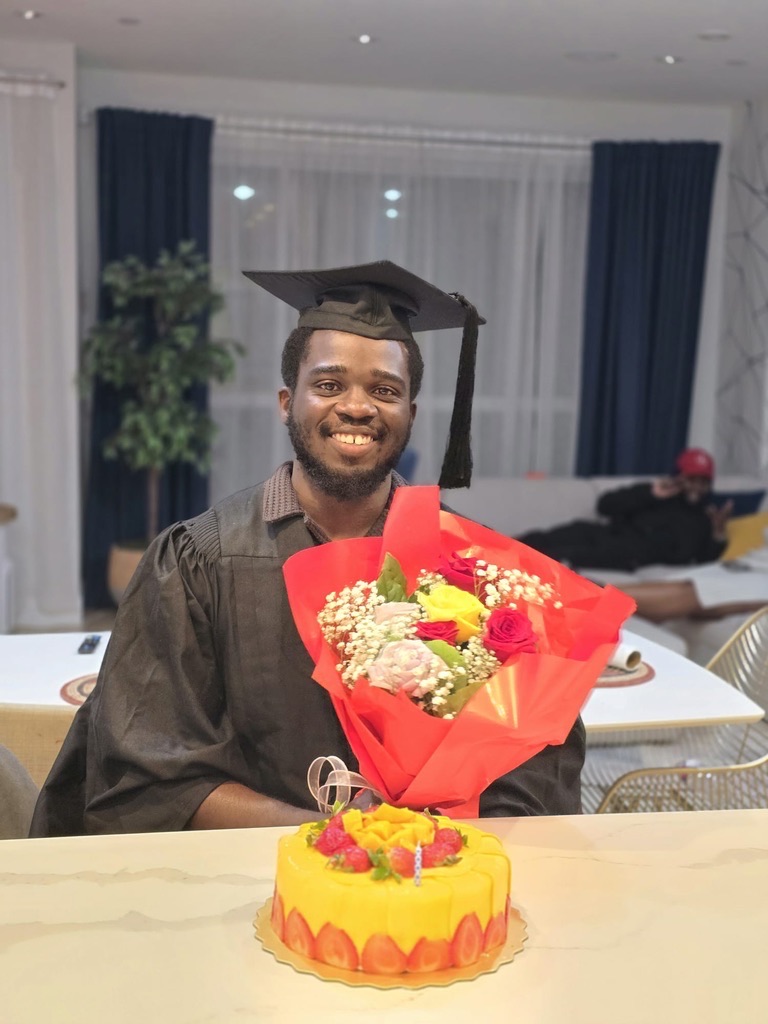 me holding flower in grad gown!
