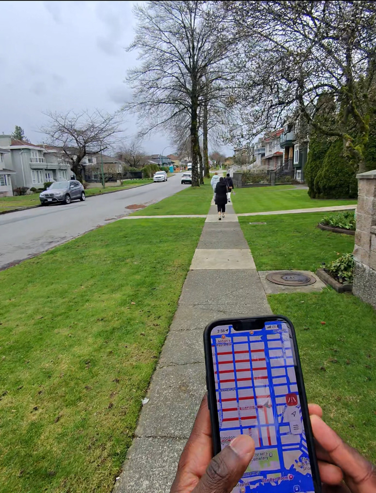 Me holding phone with Gogomi on a walk around Willingdon Heights
